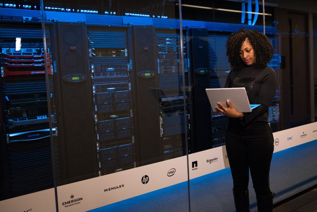 women with laptop near server